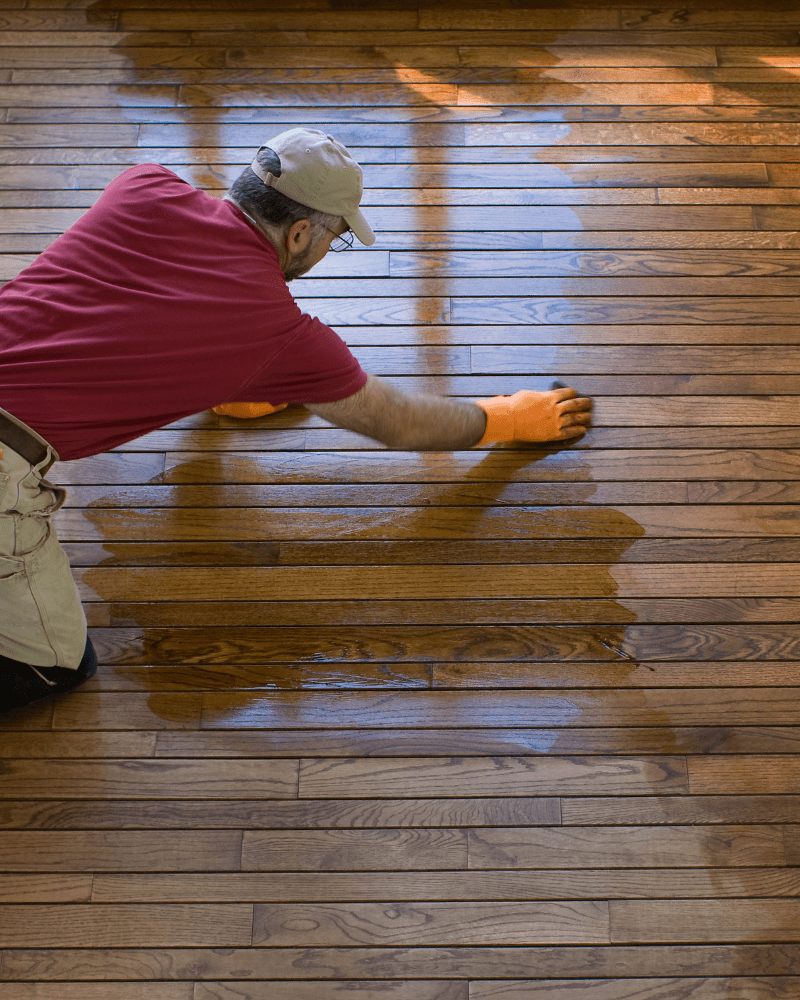 Worker cleaning Wooden floor doing Hardwood Floor Refinishing Service