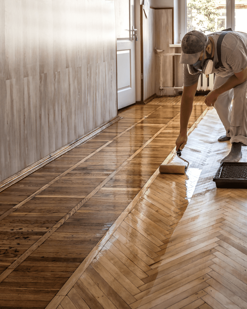 Worker shinning the freshly installed Wooden flooring